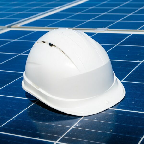 Photo d'un panneau solaire photovoltaïque avec un casque de chantier dessus (photo par evgeniy alyoshin)